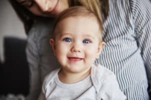 lachendes Baby auf dem Schoß der Mutter