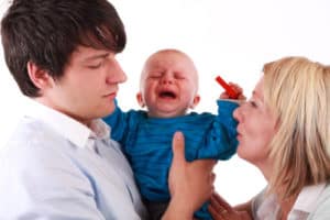 Baby schreit auf dem Arm einer fremden Person