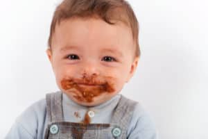 Baby Mund ist mit Schokolade beschmiert