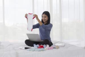 Frau verkauft gebrauchte Babykleidung online