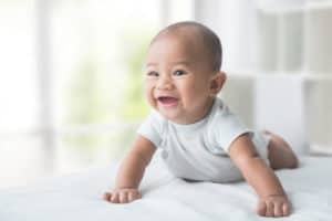 lachendes Baby liegt auf den Bauch