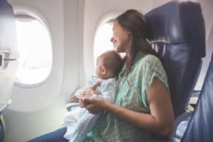 Mutter sitzt mit ihre Baby im Flugzeug