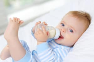 Baby trinkt Milch aus seinem Fläschchen