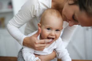 Mutter putzt die Zähne von ihrem Baby