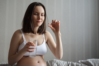 Schwangere Frau nimmt für die Gesundheit Magnesium Präparate ein