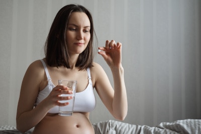 Magnesium Präparate in der Schwangerschaft Schwangere Frau nimmt für die Gesundheit Magnesium Präparate ein